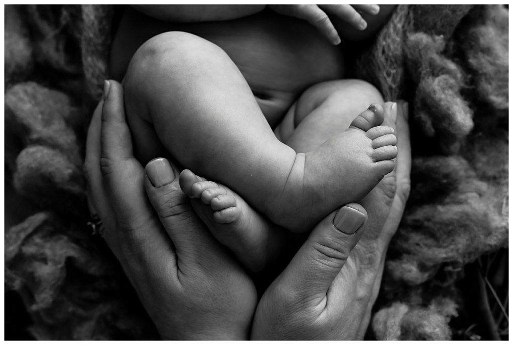 mom holding newborn baby's feet in the shape of a heart