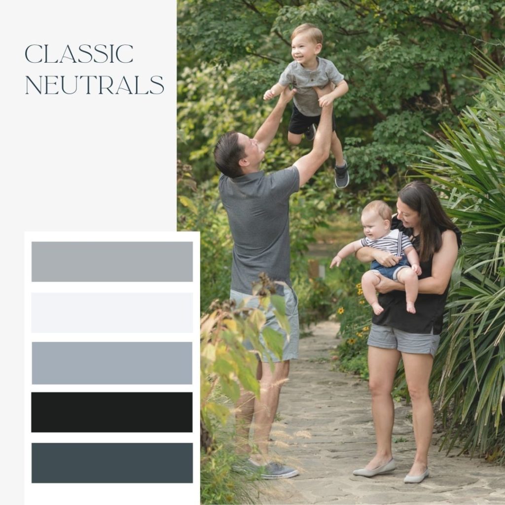 Mom, Dad, and two young children posing for playful outdoor family photos surrounded by greenery. Classic neutrals color schemes for family photos with gray, black, white, and tan shades.]
