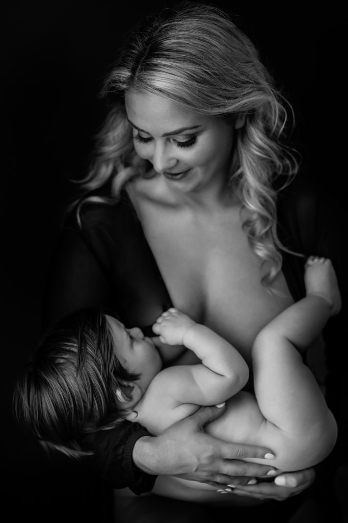A mother breastfeeds her baby for studio portraits in Leesburg