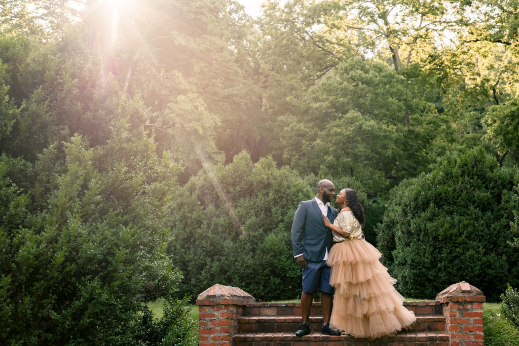 a husband and wife pose under golden sunlight in Northern Virginia 