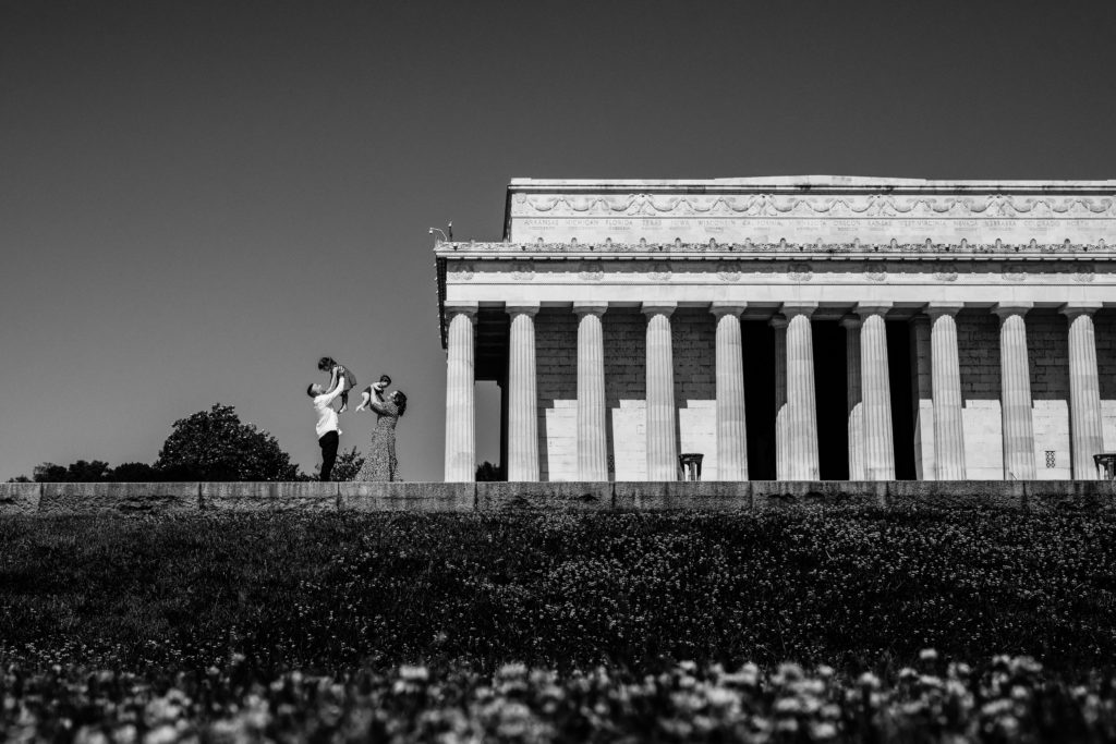 A family plays in front of the Washington Monument 