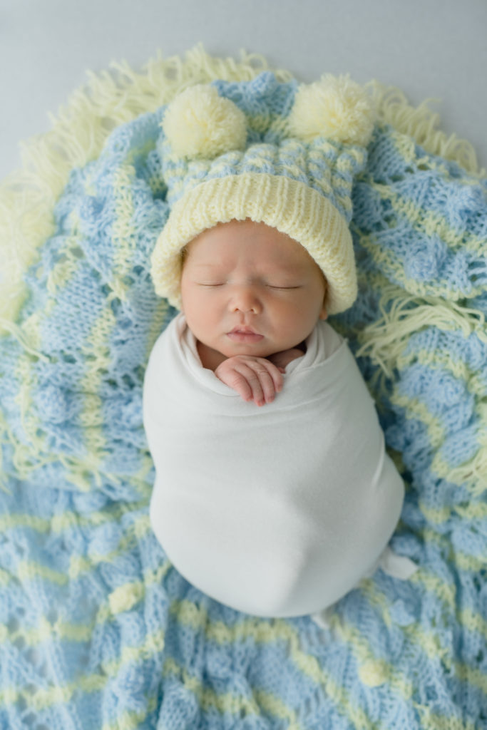 newborn with hat swaddled for newborn baby photo session